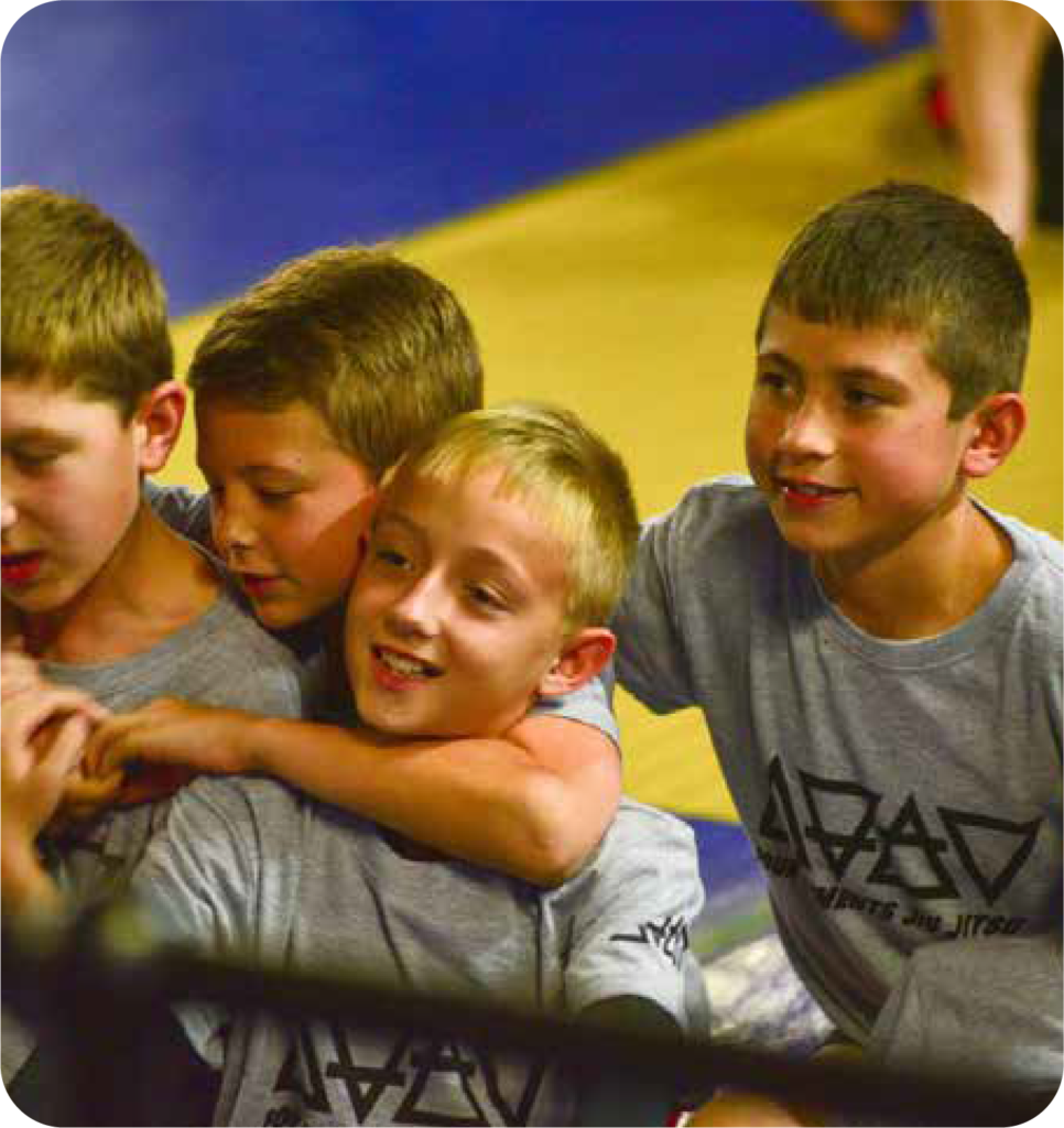 Youth practicing Brazilian Jiu-Jitsu techniques in a class setting.